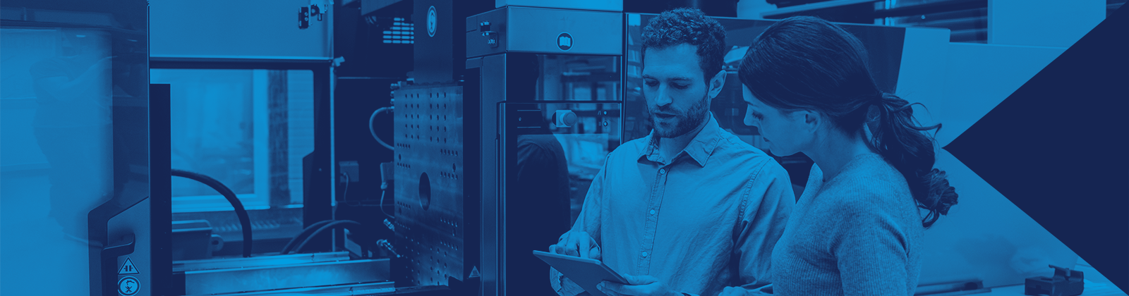 Two Employees Conversing Infront of an Injection Molding Machine
